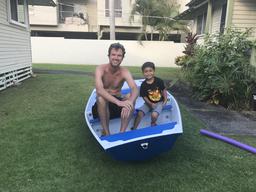 Dave and our neighbor Braden sitting in the nesting dinghy we built.