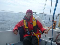 Carolyn in foul weather gear with life jacket harness and tether.